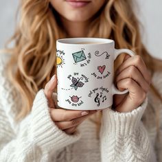 a woman is holding a coffee mug with drawings on it and the words, i love you so much