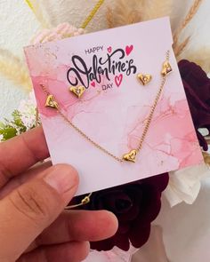 someone holding up a valentine's day card with two hearts on it and the words happy valentine's day written in gold