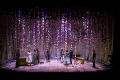 people standing on a stage with confetti falling from the ceiling and hanging down