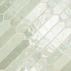 a close up view of a tile wall with white and green tiles on the bottom