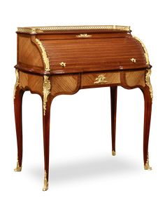 an antique wooden desk with gold trimmings on the top and bottom, sitting against a white background