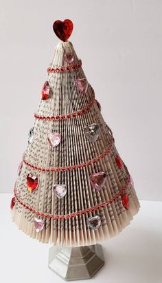 an origami christmas tree made out of books with hearts on the top and sides