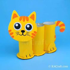 a paper mache of a cat with three cans in front of it on a blue background