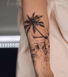 a woman's arm with a palm tree and flowers tattoo on her left forearm