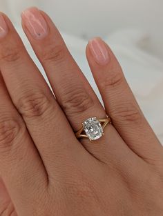 a woman's hand with a ring on it and a diamond in the middle