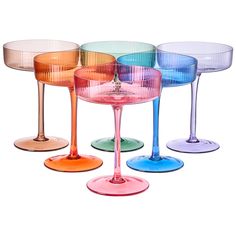 four different colored wine glasses sitting next to each other