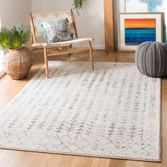 a living room with wooden floors and a white rug on the floor next to a chair