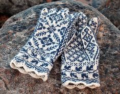 two mittens sitting on top of a large rock