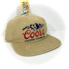 DETAILS: - Great-looking COORS BEER HAT for adults  - Tan with embroidered accents  - Officially licensed  - Unstructured crown with flat bill, retro 90s style   (new hat designed to look vintage) - Adjustable snapback - standard one size fits most adult  CONDITION: NEW WITH TAG   inventory ID#802401070TC2 Retro Flat Brim Snapback Hat For Baseball Season, Retro Snapback Hat With Embroidered Logo, Retro Embroidered Logo Snapback Hat For Streetwear, Retro Adjustable Snapback Hat For Sports, Retro Snapback Hat With Embroidered Logo And Curved Brim, Retro Hat With Embroidered Logo For Baseball Season, Retro Hat With Adjustable Flat Crown, Retro Adjustable Fitted Hat For Baseball Season, Retro Baseball Season Hat With Embroidered Logo