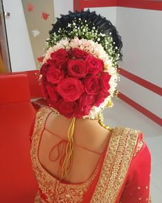 the back of a woman's head with flowers in her hair and dress on