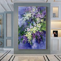 the painting is hanging on the wall in the living room, it has purple and white flowers