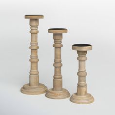 three wooden candlesticks sitting next to each other