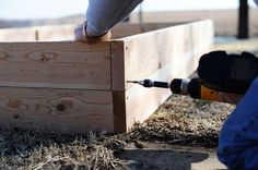 a person using a power drill to build a wooden box