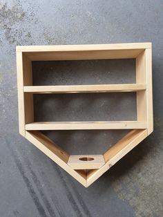 a wooden baseball bat shaped shelf on the wall with holes in it's sides