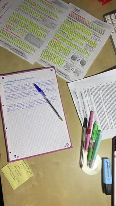 a table topped with lots of papers and pens