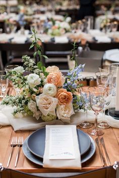 the table is set with plates, silverware and napkins for an elegant centerpiece