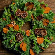 Holiday wreath made of noble fir, cedar, and pine with bay and magnolia leaves, ponderosa pine cones, and Australian pine cones up close Bay Wreath, Holiday Berries, Gold Hangers, Fresh Wreath, Fall Centerpieces, Orb Light, Fall Thanksgiving Wreaths, Window Wreath, Red Wreath