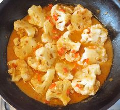 cauliflower and carrots are cooking in a skillet on the stove top