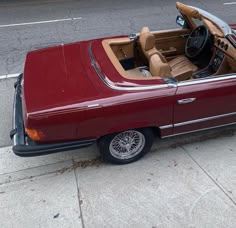 a red convertible car parked on the side of the road