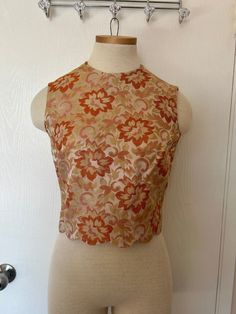 "Beautiful vintage brocade top from Gilmar Canada.  Stunning colour pallet of oranges, golds, and blush tones, scalloped bottom with side slits, and a full zip back.  I believe this would best fit someone who wears a size small/medium, please see measurements below for more accurate sizing.  All measurements are taken with the garment laying flat, and this is a non-stretch fabric.  Armpit to armpit: 17\" Waist: 14\" Collar to hem: 17\"" Fitted Floral Print Peach Tops, Fitted Peach Floral Print Tops, Fitted Cropped Peach Top, Fitted Peach Cropped Top, Fitted Gold Brocade Tops, Fitted Gold Floral Print Tops, Scallop Top, Blush Tones, Orange Yellow