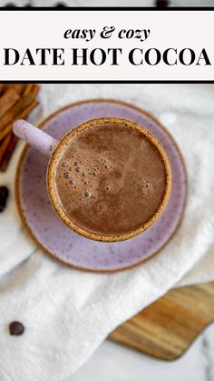 a close up of a cup of coffee on a plate with cinnamon sticks in the background