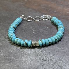 "Y'all asked for a simple, stunning Turquoise bracelet that could be paired with all your other silver and leather pieces, so here you go!   Nothing but AAA Kingman Turquoise in a stunning color, paired with handmade 99% pure silver by the Hill Tribes of Thailand.  Finished with a sterling silver toggle that allows sizing for 6.5\"; 7\"; and 7.5\" wrists.  Need a different size?  Message me and I'll be happy to help. This is a very limited batch of this turquoise so get them while you can. Side note: someone recently asked me how I sell Kingman turquoise for so much less than others and my answer was simple: I don't need to mark up my turquoise 200+%.  I want as many people as possible to be able to enjoy this beautiful stone which has cultural and personal significance for me.  So I buy t Hill Tribe Silver, Kingman Turquoise, Leather Pieces, The Hill, 7 And 7, Adjustable Bracelet, Pure Silver, Arm Band, Turquoise Bracelet