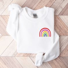 LITTLE RAINBOW GILDAN UNISEX SWEATSHIRT **IMPORTANT** These are print-on-demand sweatshirts, so please keep in mind that they can take up to 7-10 business days to be fulfilled and 3-6 business days to be shipped. Sometimes fulfillment can happen very quickly and sometimes longer than usual. The typical turnaround for production and shipping is 8-12 days. The Gildan 18000 Sweatshirts are one of the most popular heavy-weight unisex sweatshirts in the world. They're made of 50% cotton & 50% polyest Rainbow Long Sleeve Sweatshirt For Fall, Long Sleeve Rainbow Sweatshirt For Fall, White Relaxed Fit Sweater With Screen Print, Rainbow Long Sleeve Sweatshirt For Winter, Rainbow Cotton Sweatshirt For Winter, Trendy Rainbow Print Long Sleeve Tops, Trendy Long Sleeve Rainbow Print Tops, Trendy Long Sleeve Tops With Rainbow Print, Casual Rainbow Crew Neck Sweatshirt