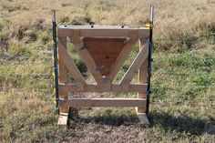 a wooden structure in the middle of a field