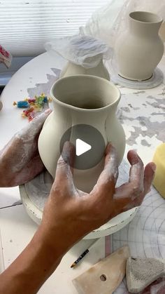 a person is making pottery on a table