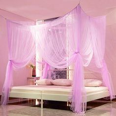 a pink canopy bed with white sheets and pillows