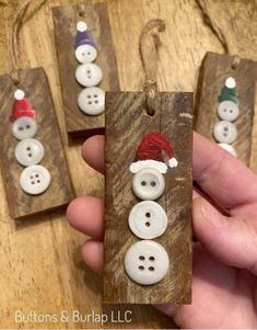 three wooden tags with buttons and santa hats on them