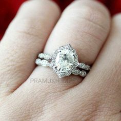 a woman's hand with a diamond ring on top of her finger and the engagement band