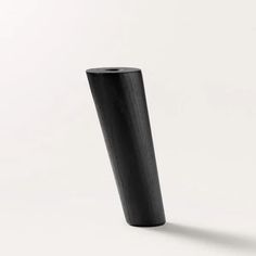 a tall black vase sitting on top of a white floor