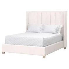 a white bed with two pillows on top of it