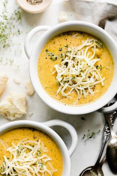 two bowls of soup with cheese on top