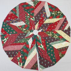 a red, green and white quilted christmas tree skirt