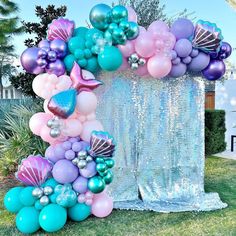 an arch made out of balloons and mermaid tailes