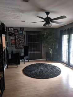 a living room filled with furniture and a ceiling fan