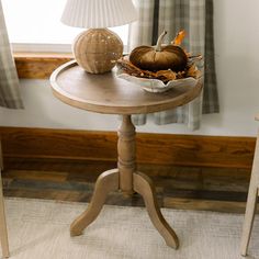 a wooden table topped with a bowl of pumpkins