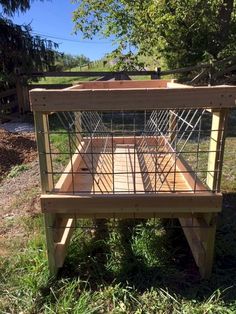 a wooden bench made out of wood and wire with a metal cage on the top