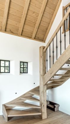 a wooden stair case in a white room