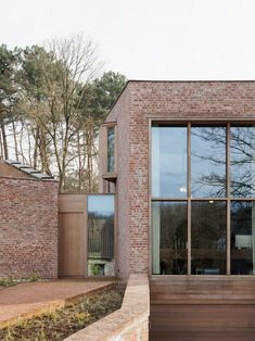 an exterior view of a brick house with large windows