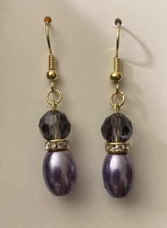 Gold toned earring wire made of zinc and iron alloy. It's lead and nickel free. It's a dusty purple colored crystal with a gold spacer with crystals in it.  It has a glass Pearl on the bottom in a dusty purple color. Elegant Purple Beaded Earrings, Elegant Purple Beaded Earrings With Ear Wire, Purple Drop Crystal Earrings, Elegant Purple Wire Wrapped Crystal Earrings, Purple Crystal Drop Earrings, Crystal Pearl Earrings, Earring Wire, Dusty Purple, Purple Crystal