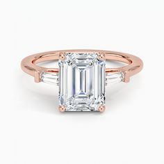 an emerald - cut diamond ring with three baguets on the band and side stones