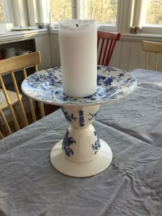 a candle sits on top of a blue and white plate