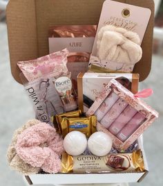 a gift box filled with pink and gold items for someone's special occasion or baby shower