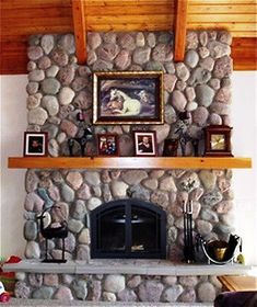 a stone fireplace with pictures on the mantle