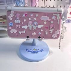 a pink laptop computer sitting on top of a white table next to a key chain