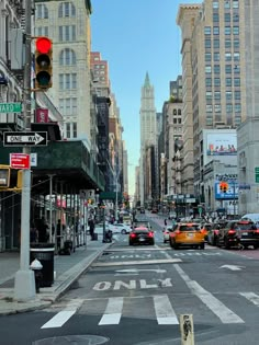 a city street filled with lots of traffic and tall buildings on either side of it