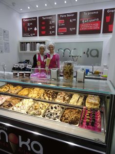 two women behind the counter of a donut shop